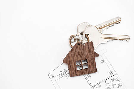 House key on a pendant in the shape of a house. real estate concept. flat layの写真素材