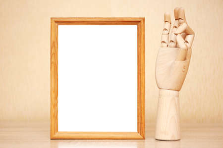 Photo frame on the table and wooden hand showing okの写真素材