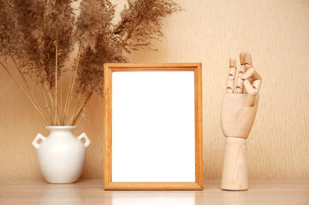 Composition with frame and wooden hand on tableの写真素材