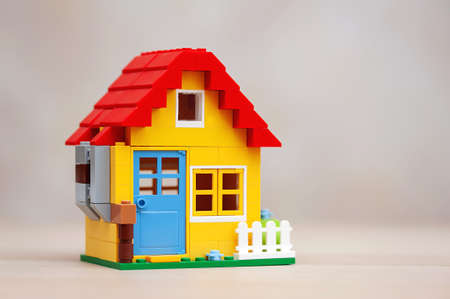 real estate concept. Model of a country house with a red roof on a neutral backgroundの写真素材