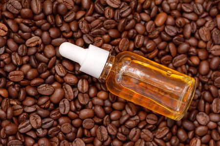 Glass bottle with coffee essential oil and coffee beansの写真素材