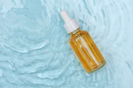 Facial serum on blue water background, copy spaceの写真素材