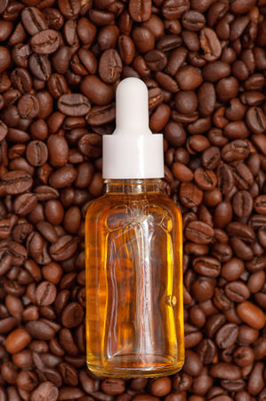 Glass bottle with coffee essential oil and coffee beans. vertical photo