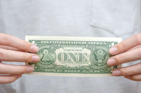 One dollar in the hands of a young man close upの写真素材