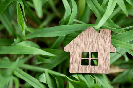 Model of a wooden house on a background of green grass. Country real estate, wooden houses, eco-friendly materialsの写真素材