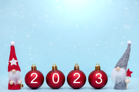 2023 New Year background. Christmas balls with numbers of the year and little gnomes on a blue...