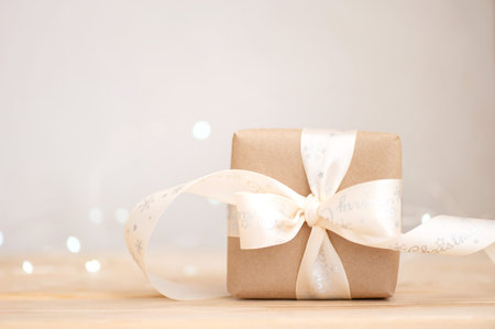 Christmas present in kraft paper on wooden table, eco friendly christmas holiday concept