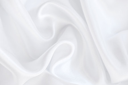 Abstract background of white silky fabric waveの写真素材