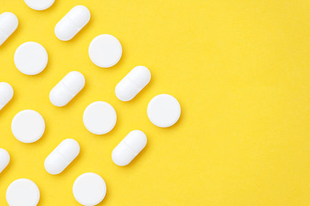 White pills on a yellow backgroundの写真素材