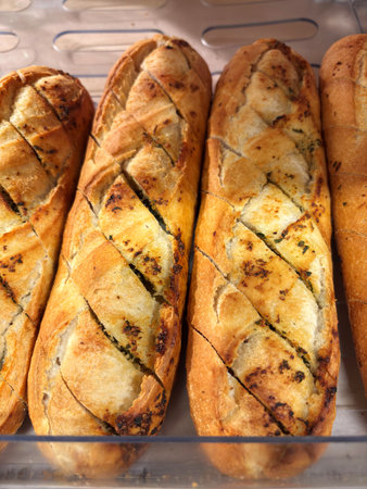 French baguette with garlic and herbs on a shelf in a supermarketの写真素材