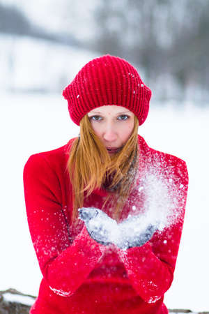The beautiful blonde girl in red hat in the forest. Girl in winter. White snow. Little Red Riding Hood.の写真素材