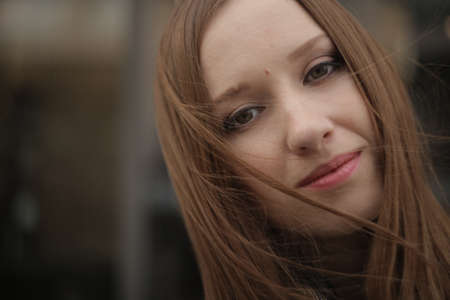 The girl in black coat in the city. Shawl, handkerchief on a person.の写真素材