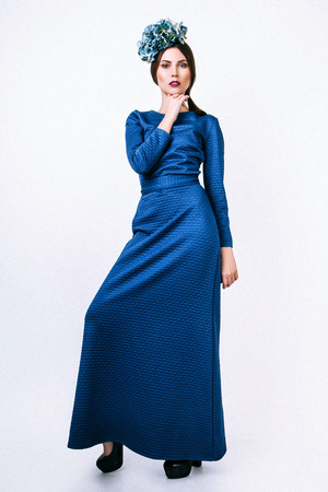Young sexy girl. Fashion portrait of young beautiful woman in long blue dress. White backgroundの写真素材