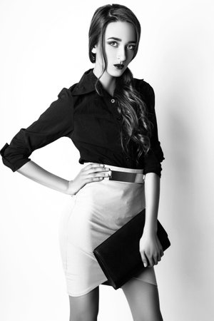 Fashion photo of young magnificent woman on white background. Girl posing. Studio photo. Black and whiteの写真素材