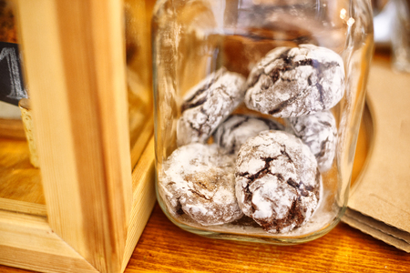 Scented glazed gingerbread in a transparent glass jar are on the table in a cafe. Close-up viewの写真素材