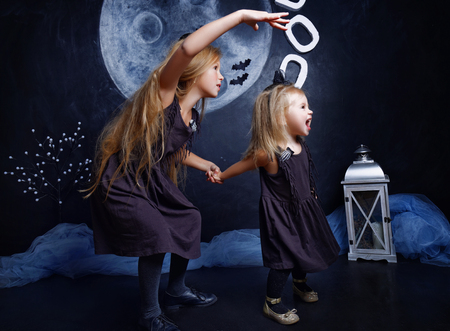 two little girls in costumes witches, sister scares little. The concept of Halloweenの写真素材
