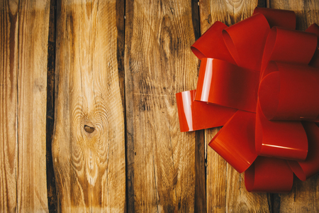 Wooden background with red bow and ribbon with copy spaceの写真素材