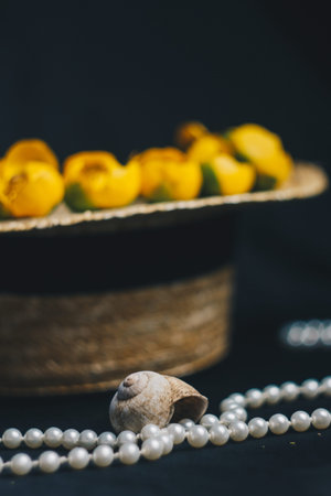 still life shell of a snail against the background of a summer straw hat with flowers of water...