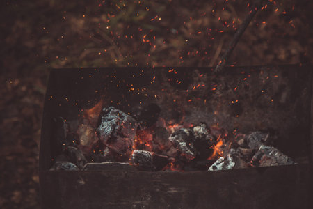 charcoal smolder in the iron grill. cooking picnic outdoors. sparks over the embers top view close...