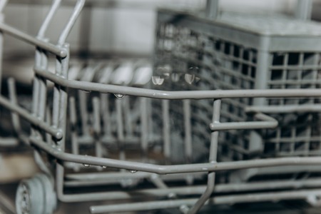 empty open dishwasher closeup. cutlery compartment close-up. household appliances in the kitchen macro.の写真素材
