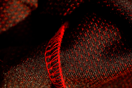 red sportswear closeup top view. seam and juncture inside out. breathable knitwear. clothing details macro.の写真素材