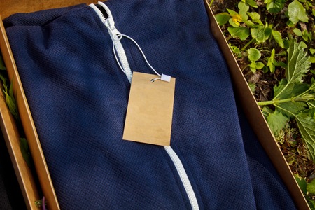 colorful sportswear with tags folded in cardboard boxes lie on the ground with grass. packed clothing top view. unpacking purchases.の写真素材