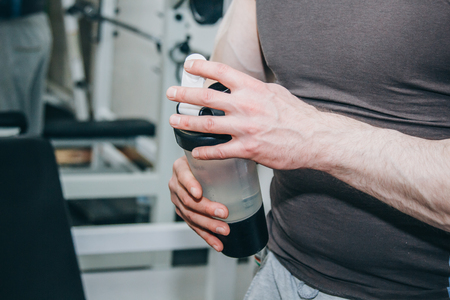 athlete with big hands resting between exercises in the training center. training tools in the gym close-up.の写真素材