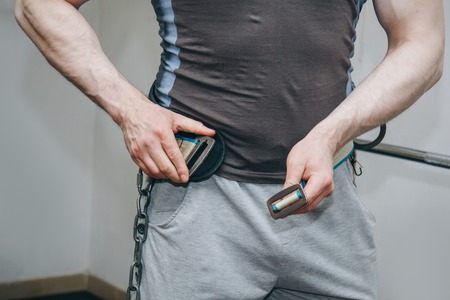 athlete wears a waist belt in the training center. training tools in the gym close-up.の写真素材
