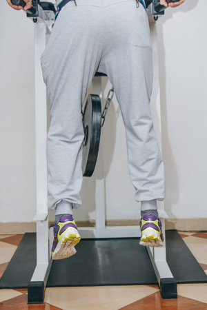 athlete doing exercise with weight on the waist belt in the center of training. training tools in...