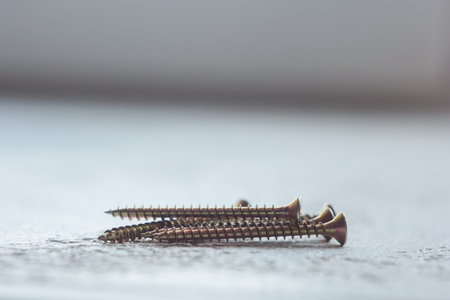 metal screws on the tree close-up on a blurred background. bolts close-up on the table. copy space.の写真素材