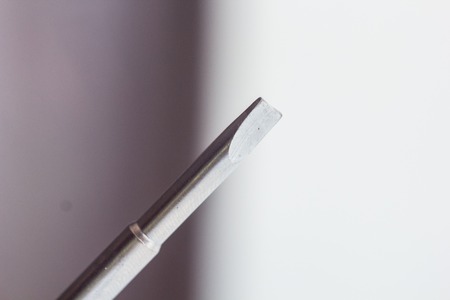 head of a metal flat screwdriver close-up on a blurred background. hand tool close up. copy space.の写真素材