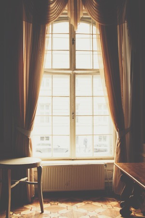 wooden window with vintage curtains and square molding on a sunny day. beige satin curtains. interior. background for collage.の写真素材
