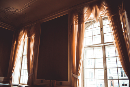 wooden windows with vintage curtains and square moldings on a sunny day. beige satin curtains. interior. background for collage.の写真素材