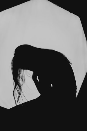 a girl with long hair in the image of a witch is trying to set herself on fire. rituals with candles for love spell and damage. expulsion of a bad spirit from the body.の写真素材