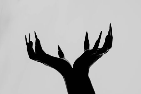 a girl with long hair in the image of a witch is trying to set herself on fire. rituals with candles for love spell and damage. expulsion of a bad spirit from the body.の写真素材