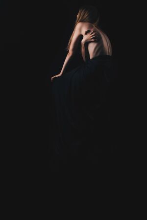 A girl with a bare back, severe thinness and protruding ribs. The concept of anorexia and bulimia, a disease of thin people. The struggle of the evil spirit in a girl, suffering and povertyの写真素材