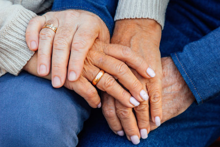 hands of an elderly couple close-up with a wedding ring on a finger