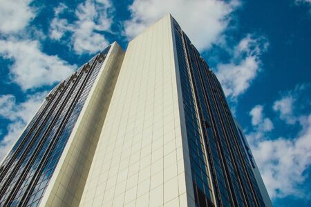 A skyscraper with lots of windows against a beautiful blue sky. Business and financial conceptの写真素材