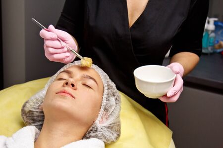 preparation for procedures in the cosmetologist s office. applying the gel to the face with a special brushの写真素材