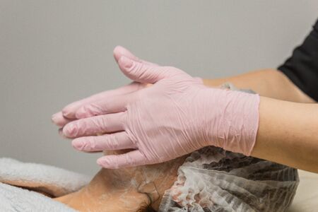 concept beautician. The hands of a cosmetologist put cream on the face of a woman. Beautician applies a cream to the face of the girlの写真素材