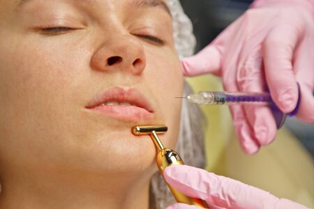 contour plastic. A cosmetologist injects a botulinum toxin to tighten and smooth out wrinkles on the skin of a female faceの写真素材