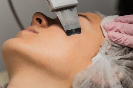 close-up. Ultrasonic face cleaning. Modern equipment. Beautician does cosmetic procedure on woman...