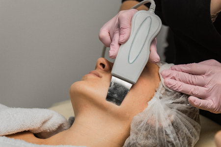 close-up. Ultrasonic face cleaning. Modern equipment. Beautician does cosmetic procedure on woman...