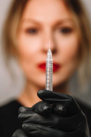 contour plastic. A cosmetologist injects a botulinum toxin to tighten and smooth out wrinkles on the skin of a female faceの写真素材