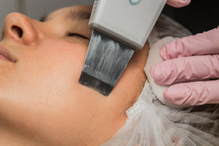 close-up. Ultrasonic face cleaning. Modern equipment. Beautician does cosmetic procedure on woman...