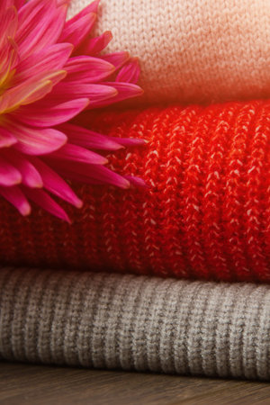 Pattern of colorful knitted sweaters closeup. Handmade merino wool product. A stack of folded...