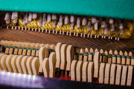 This photo shows the soul of a piano. Thick base strings of the piano have their own beauty. Creative perspective and interesting lighting give this photo an authentic charmの写真素材