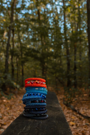 Beautiful, shiny, colorful bracelet set with large beadwork beads. On a wooden bench in the park....