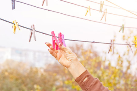 Laundry woman hangs clean wet cloth on clothes dryer after washing at home. Household chores and...
