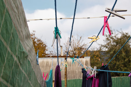 A clothespin hangs on the washing line. A rope with clean linen and clothes outdoors on the day of...